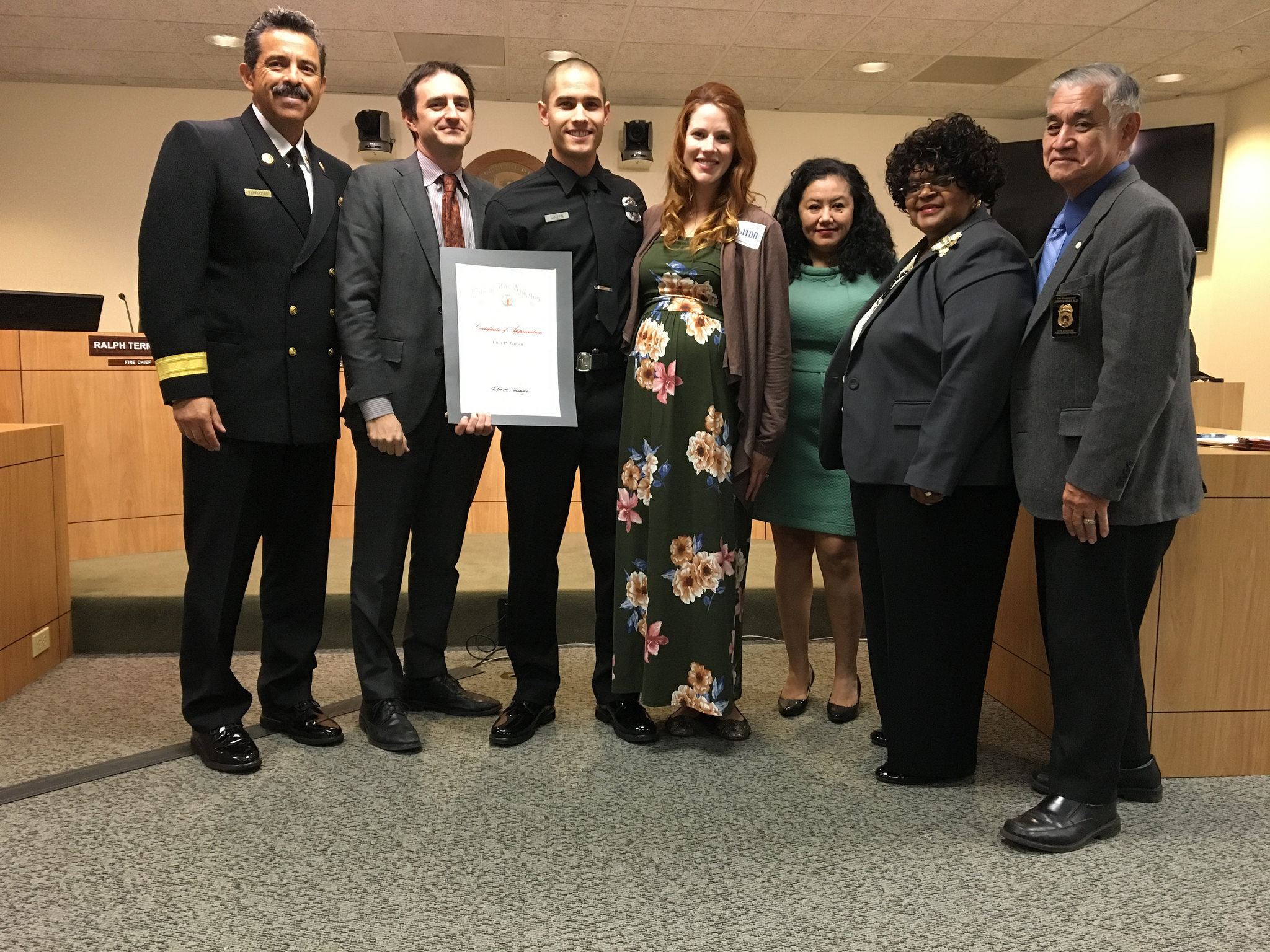 Image of Firefighter awardee standing with with wife, Fire Chief and members of the Board of Fire Commissioners