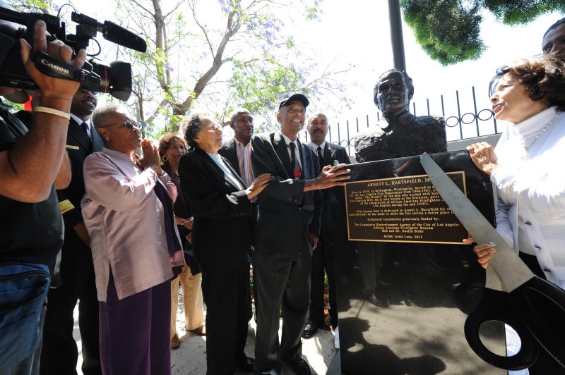 Arnett Hartsfield, Jr. smiling during dedication of bronze statue surrounded by supporters 