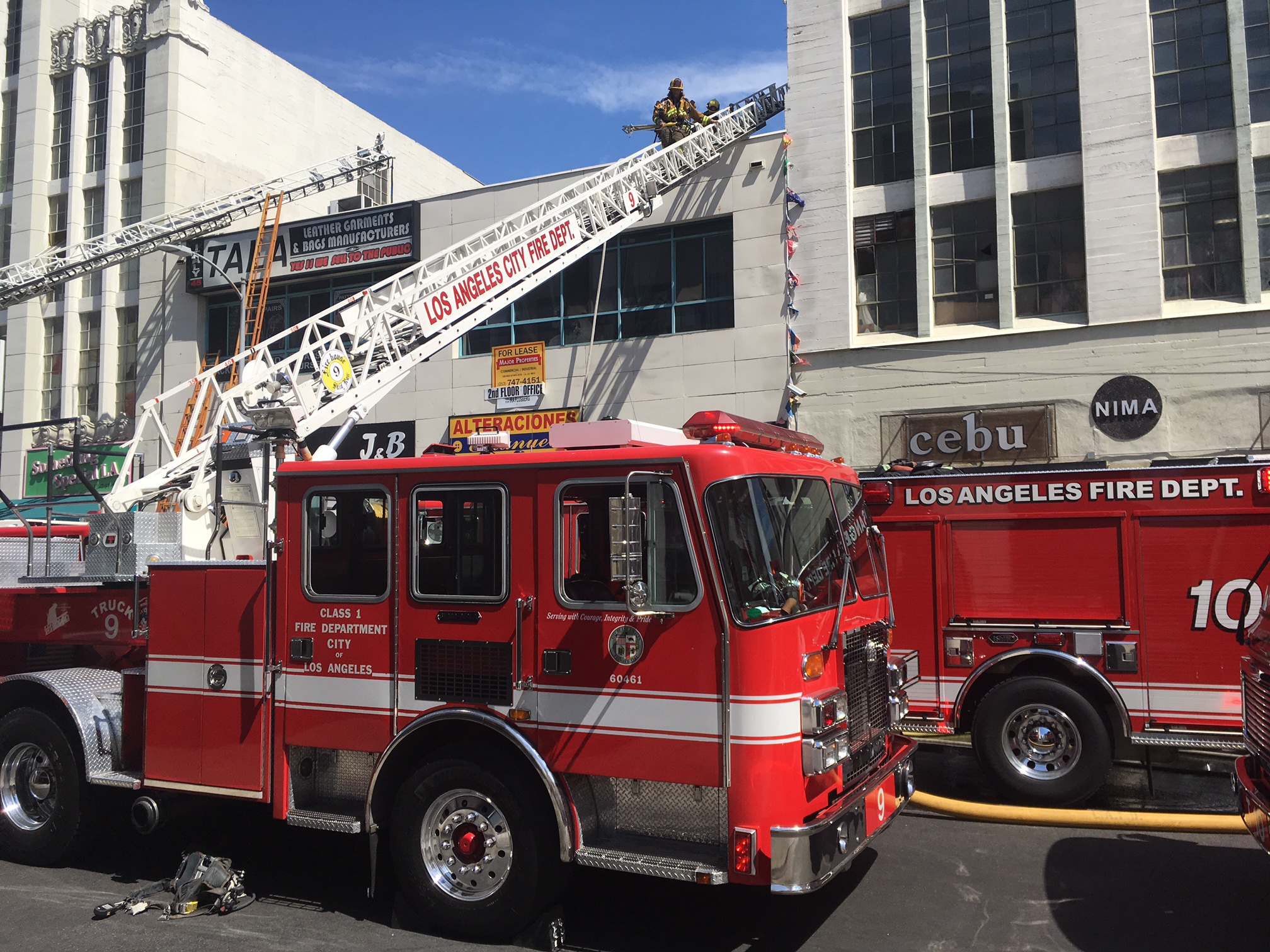 Fire engines in front of building with ladders to roof