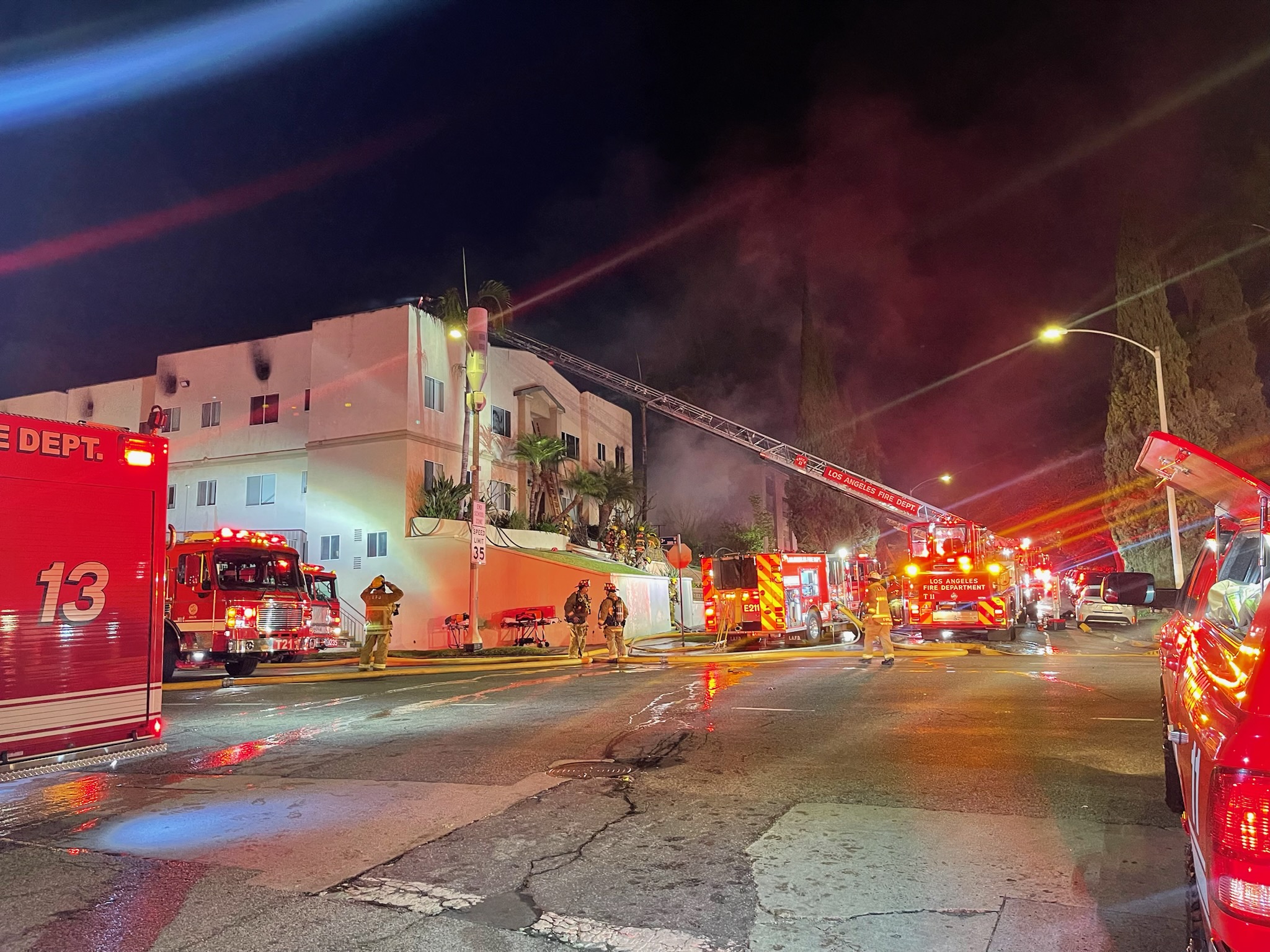 Fire Department apparatus surrounding a 2-story apartment building during a fire