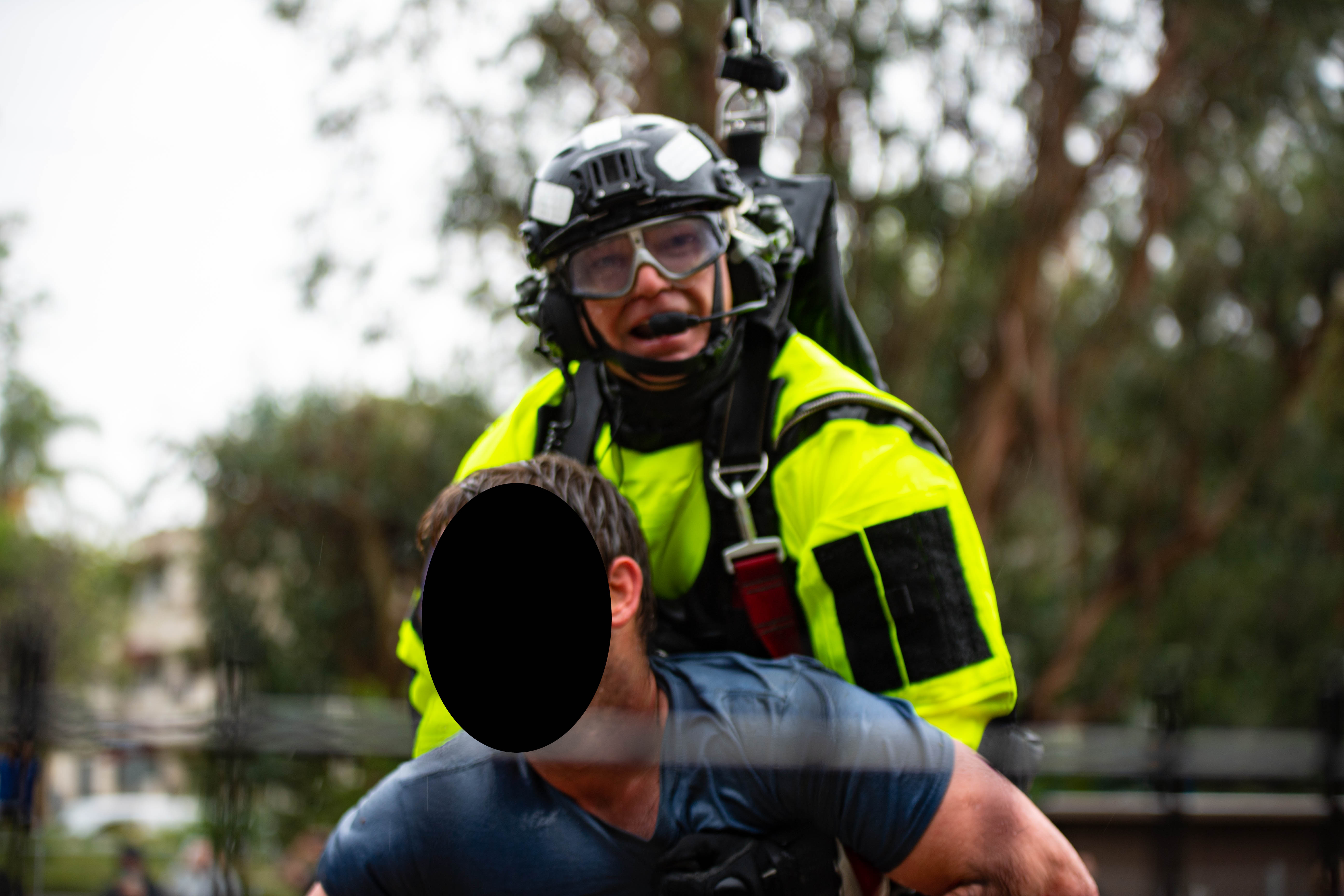 Firefighter rescuer with civilian strapped to him after coming out of the water