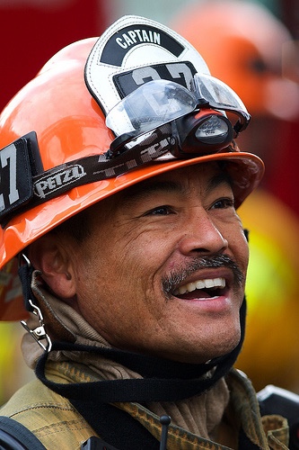 Close photo of subject in uniform with helmet on, smiling